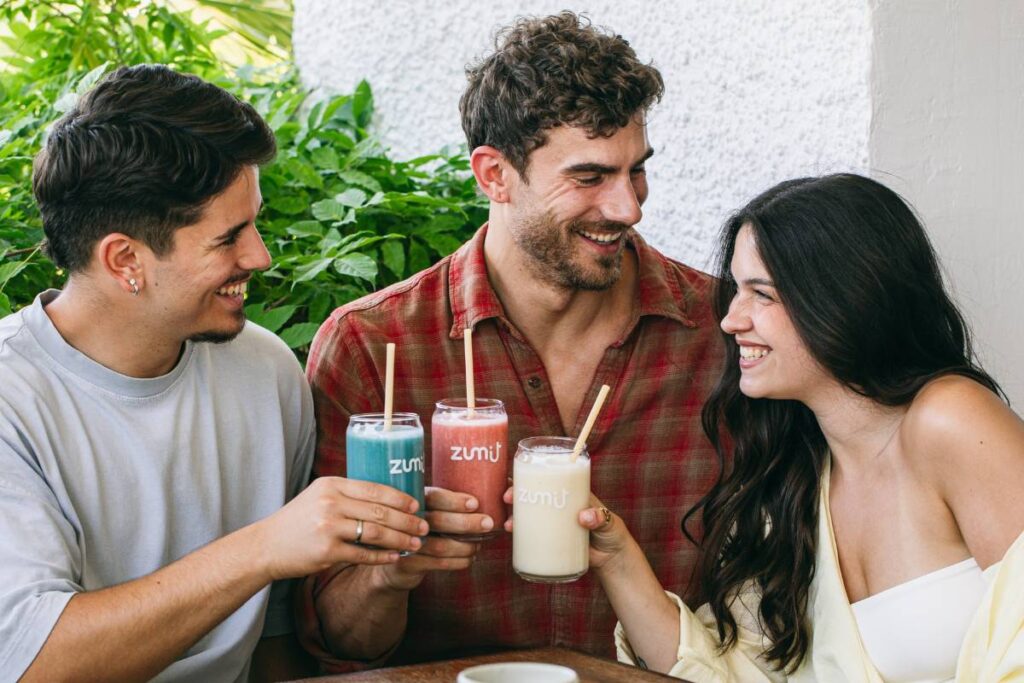 Smoothies Zumit en unas manos de unas personas mientras hablan entre ellos